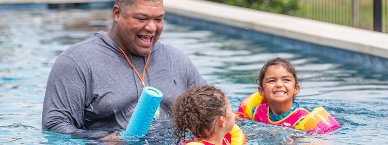 Dad watching children in swimming pool